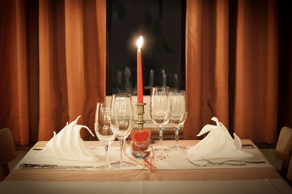 Table setup with a red candle at the center for Valentine's dinner